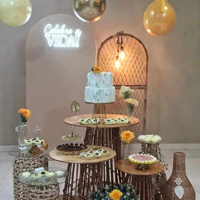 Mesa de doces elegante com bolo branco, flores e letreiro neon Celebre a Vida em festa na Mimo Casa de Festa