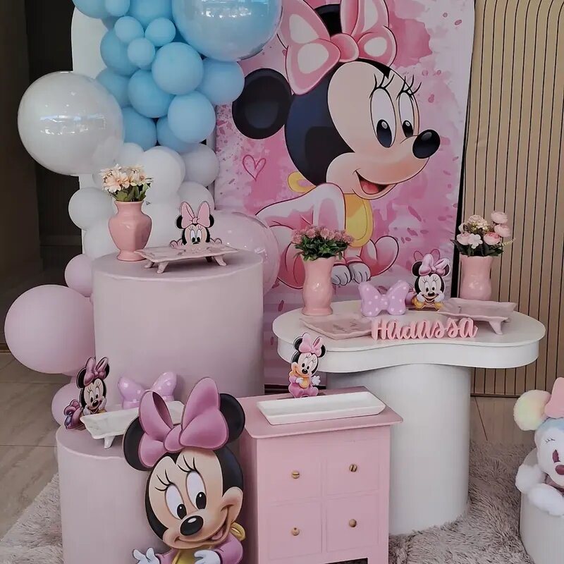 Decoração temática da Minnie Mouse com painel rosa, balões azuis e brancos e mesa personalizada para festa infantil