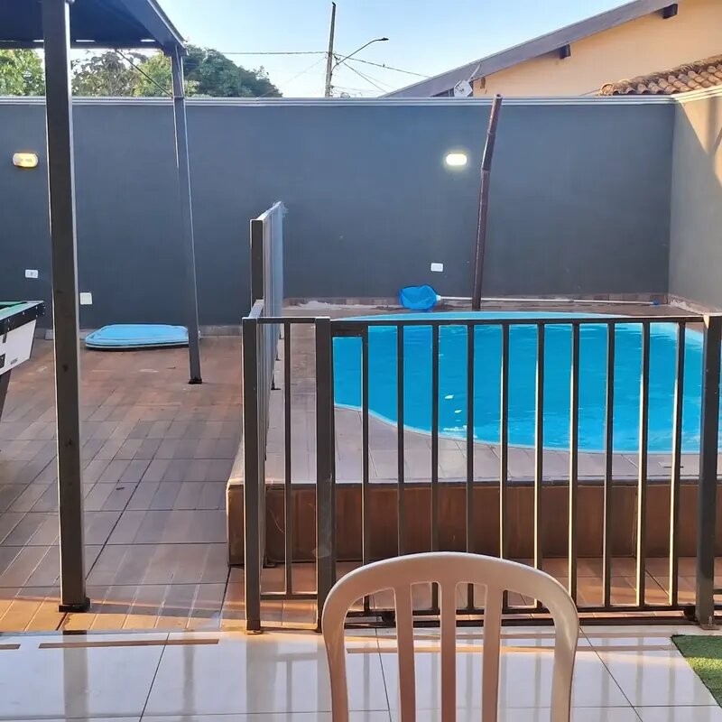 Piscina iluminada com água azul e grade de segurança na Mimo Casa de Festa, Campo Grande MS